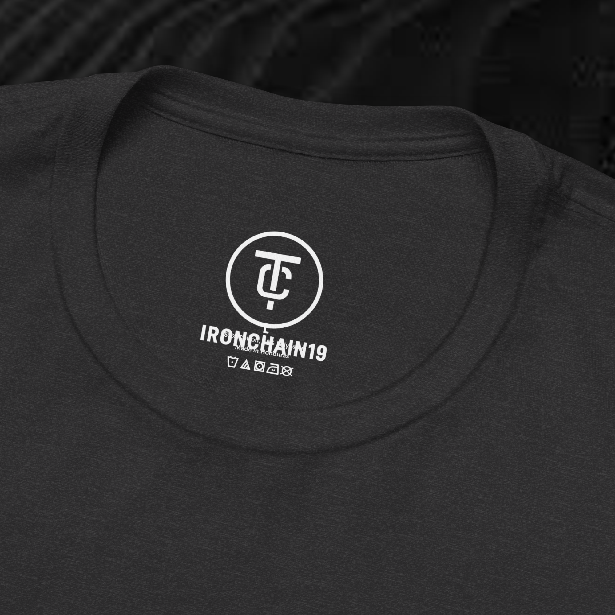 A close-up of the inside collar of a  cotton t-shirt from Ironchain 19. The tagless printed label features a sleek white logo with a chain illustration, surrounded by number19 . Below the logo, the text indicates the shirt is 100% cotton, made in Bangladesh, and includes washing care symbols. The soft fabric and seamless neckline highlight the premium quality and comfort of this Gothic aesthetics  perfect for cat lovers and fans of modern streetwear fashion.