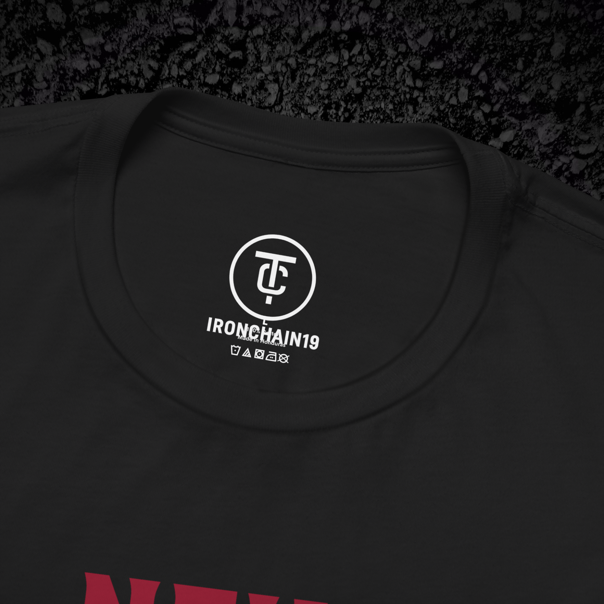 A close-up of the inside collar of a  cotton t-shirt from Ironchain 19. The tagless printed label features a sleek white logo with a chain illustration, surrounded by number19 . Below the logo, the text indicates the shirt is 100% cotton, made in Bangladesh, and includes washing care symbols. The soft fabric and seamless neckline highlight the premium quality and comfort of this Gothic aesthetics  perfect for cat lovers and fans of modern streetwear fashion.