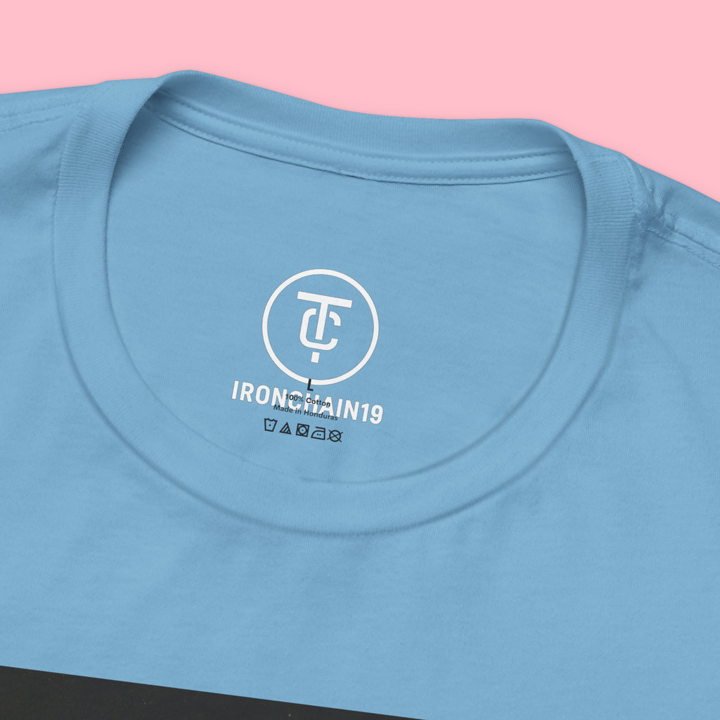 A close-up of the inside collar of a  cotton t-shirt from Ironchain 19. The tagless printed label features a sleek white logo with a chain illustration, surrounded by number19 . Below the logo, the text indicates the shirt is 100% cotton, made in Bangladesh, and includes washing care symbols. The soft fabric and seamless neckline highlight the premium quality and comfort of this Gothic aesthetics  perfect for cat lovers and fans of modern streetwear fashion.