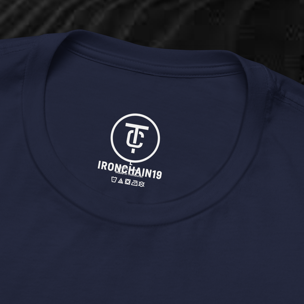 A close-up of the inside collar of a  cotton t-shirt from Ironchain 19. The tagless printed label features a sleek white logo with a chain illustration, surrounded by number19 . Below the logo, the text indicates the shirt is 100% cotton, made in Bangladesh, and includes washing care symbols. The soft fabric and seamless neckline highlight the premium quality and comfort of this Gothic aesthetics  perfect for cat lovers and fans of modern streetwear fashion.