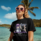 Black tee showcases Fern from Frieren, lounging with bare feet visible, her eyes focused and her presence magical and soothing.