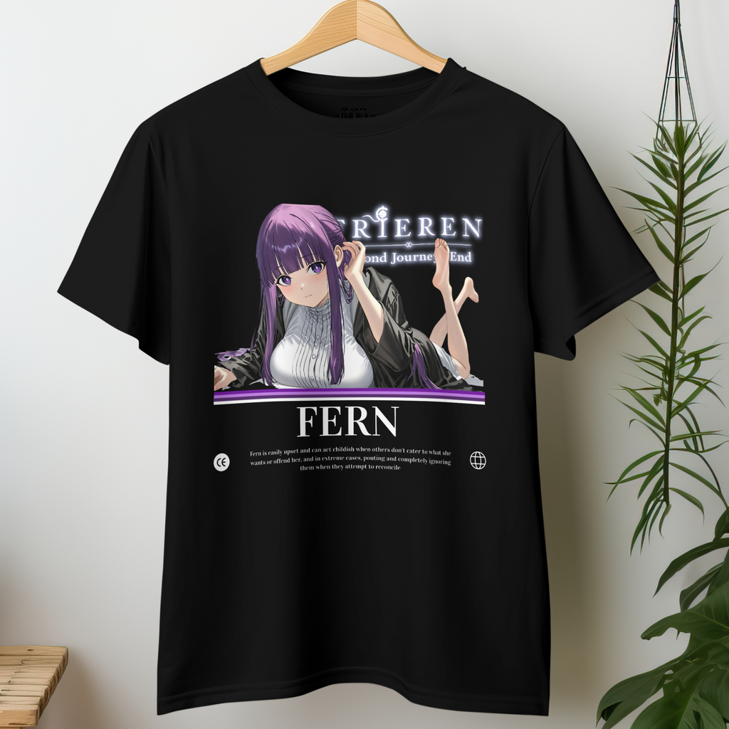 Fern from Frieren lays on her stomach, feet playfully lifted behind her, with soft purple hair and a gentle yet confident gaze, printed on a black tee.