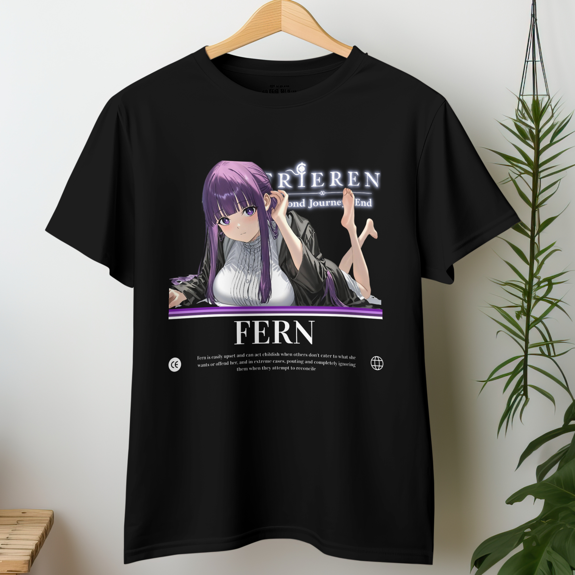 Fern from Frieren lays on her stomach, feet playfully lifted behind her, with soft purple hair and a gentle yet confident gaze, printed on a black tee.